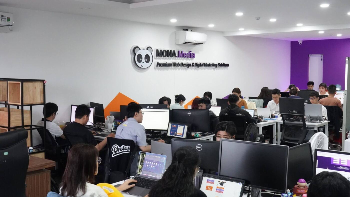 Văn phòng MONA Media rộng thoáng với dãy bàn làm việc và màn hình